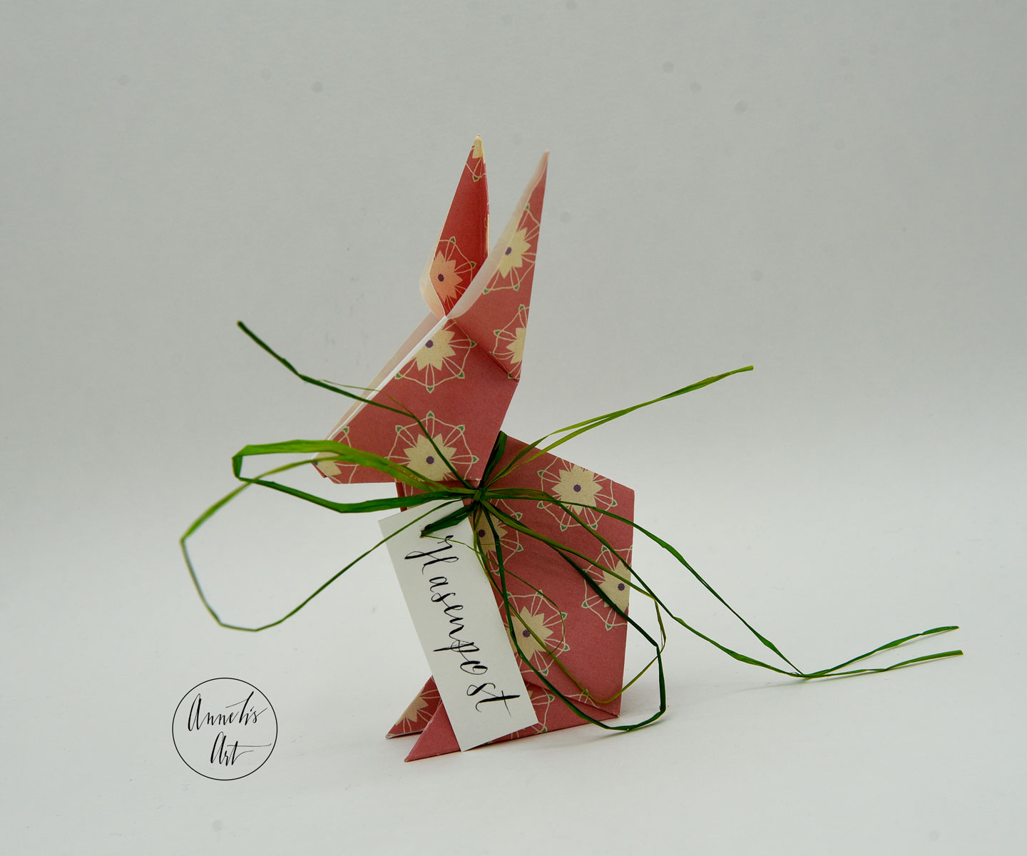 Rosa Origami Osterhase mit grünem Band und Muster
