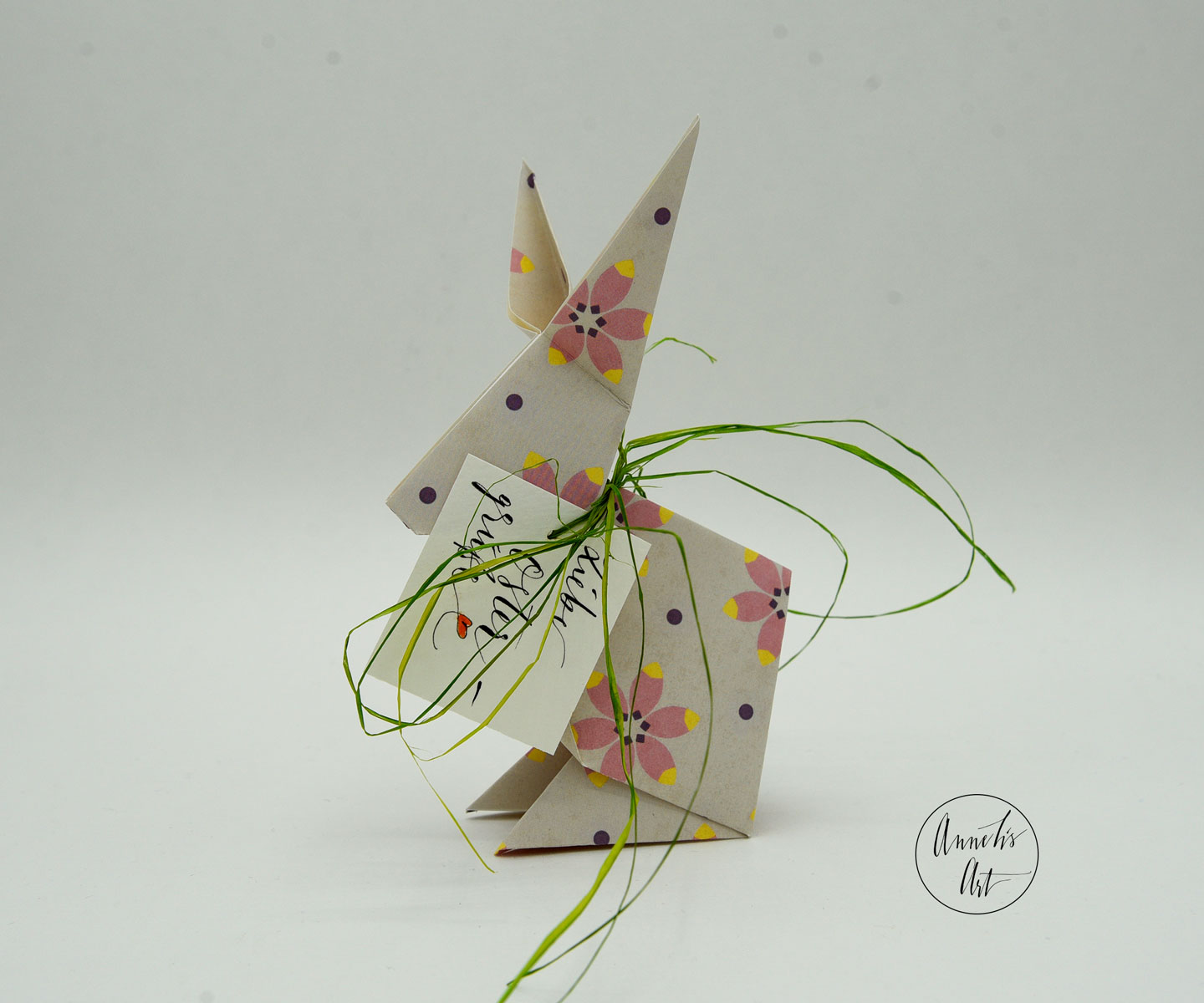 Rosablumiger Origami Osterhase mit grünem Band und Muster 